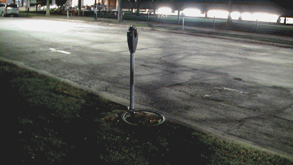 granualated image of a bike tire locked to a parking meter.